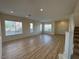 Spacious living room with hardwood floors, large windows, and a staircase at 1327 Coulisse St, Henderson, NV 89052