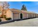 Exterior garages with tan doors, tile roof, bushes, and visible unit numbers at 1600 N Torrey Pines Dr # 202, Las Vegas, NV 89108