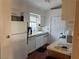 A compact kitchen featuring white appliances, white cabinetry, laminate countertops, and tile backsplash at 1600 N Torrey Pines Dr # 202, Las Vegas, NV 89108