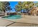 Community pool with clear blue water, trees, and lounge area at 1600 N Torrey Pines Dr # 202, Las Vegas, NV 89108