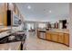 Open kitchen with island, stainless steel appliances, and wood cabinets at 2090 Lewiston Pl, Henderson, NV 89044