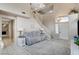 Living room with high ceilings, large windows, gray couch and staircase at 2153 Eaglecloud Dr, Henderson, NV 89074