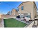 Beautiful backyard featuring an outdoor patio, green grass, a grill, and a cozy seating area under festive string lights at 3812 Seyfert Ave, North Las Vegas, NV 89084