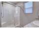 Bathroom featuring a white tile shower with a glass door and bright natural light from the window at 3812 Seyfert Ave, North Las Vegas, NV 89084