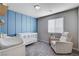 Charming Bedroom featuring a white crib, accent wall, comfortable recliner, and plenty of natural light at 3812 Seyfert Ave, North Las Vegas, NV 89084