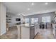 Bright, open-concept living space with kitchen island, stainless steel appliances, and a view of the living room at 3812 Seyfert Ave, North Las Vegas, NV 89084