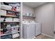 Functional laundry room featuring a washer, dryer, and ample storage space on built-in shelving at 3812 Seyfert Ave, North Las Vegas, NV 89084