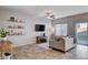 Bright living room featuring a ceiling fan, wall decorations, and sliding glass doors to the patio at 3812 Seyfert Ave, North Las Vegas, NV 89084