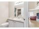 Neutral bathroom featuring granite counters, a large mirror, and a view to a combined laundry area and living room at 4248 Tolkien Ave, Las Vegas, NV 89115