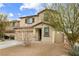 Two-story house with beige exterior, brown accents, and a two-car garage at 4904 Siglo St, North Las Vegas, NV 89031