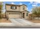 Two-story house with beige exterior, brown accents, and a two-car garage at 4904 Siglo St, North Las Vegas, NV 89031