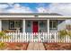 Front entrance with red door, white picket fence, and walkway at 5521 Money St, Pahrump, NV 89048