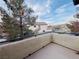 The balcony provides an outdoor space with views of neighborhood homes and mature trees, under a partly cloudy sky at 5710 E Tropicana Ave # 2122, Las Vegas, NV 89122