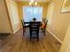 A well lit dining area features a wooden table and chairs, with a large window providing natural light to complement neutral walls at 5710 E Tropicana Ave # 2122, Las Vegas, NV 89122