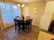 A dining room features wood floors, a chandelier, and large window that provides natural light and complements the neutral walls at 5710 E Tropicana Ave # 2122, Las Vegas, NV 89122