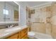 Clean bathroom with beige tile shower/tub combo, wood vanity, and large mirror at 607 Sierra Ln, Henderson, NV 89002