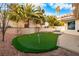 Landscaped backyard with putting green and palm trees at 7944 Marbella Cir, Las Vegas, NV 89128