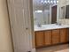 Double vanity bathroom with wood cabinets and a mirrored medicine cabinet at 9712 Tiaquinn Ave # 101, Las Vegas, NV 89129