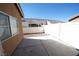 View of the backyard featuring a concrete patio area with gravel and a white fence at 1025 Chestnut Bay Ave, North Las Vegas, NV 89031