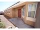 Exterior shot of the front entrance with a red front door, small porch, and desert landscaping at 1025 Chestnut Bay Ave, North Las Vegas, NV 89031