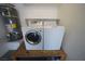 Bright laundry room features modern, white washer and dryer sets, and a tank water heater at 1025 Chestnut Bay Ave, North Las Vegas, NV 89031
