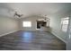 Bright, open living room with wood-look flooring, a ceiling fan, and a partial view of the kitchen at 1025 Chestnut Bay Ave, North Las Vegas, NV 89031