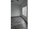 Bright, simple bedroom with hardwood floors, a modern ceiling fan, and a large window at 10337 Adams Chase St, Las Vegas, NV 89183
