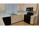 Well-lit kitchen with white cabinets, black appliances, and stainless steel sink under a window, creating a stylish cooking space at 10337 Adams Chase St, Las Vegas, NV 89183