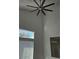 High ceiling living room with large ceiling fan and window at 10337 Adams Chase St, Las Vegas, NV 89183