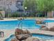 Community pool featuring rock features, metal handrails, and manicured landscape at 11870 Tevare Ln # 2086, Las Vegas, NV 89138
