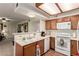 Galley kitchen with white appliances and wood cabinets at 1575 W Warm Springs Rd # 1113, Henderson, NV 89014