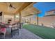 Covered patio boasts an outdoor kitchen, seating area, stone pillar, and brick flooring at 2425 Amatrice St, Henderson, NV 89044