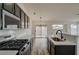 Modern kitchen with dark cabinetry, quartz countertops, and gas range at 2920 Saddle Hills Ct, North Las Vegas, NV 89031