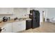 Practical kitchen featuring white cabinets, black appliances, and wood-look laminate flooring at 3473 Monte Carlo Dr, Las Vegas, NV 89121