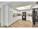 Well-lit kitchen showcasing white cabinets, black appliances, and wood-look laminate flooring at 3473 Monte Carlo Dr, Las Vegas, NV 89121