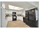 Spacious kitchen features white cabinets, black appliances, and wood-look laminate flooring at 3473 Monte Carlo Dr, Las Vegas, NV 89121