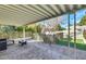 Covered patio with decorative ivy, stone flooring, wrought iron fencing, and a seating area for outdoor enjoyment at 3473 Monte Carlo Dr, Las Vegas, NV 89121