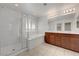 Bright bathroom featuring a walk-in shower, soaking tub, and double vanity with a dark wood finish at 365 Andy Wheeler Dr, Henderson, NV 89011