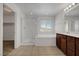 Bright bathroom featuring a separate shower, soaking tub, and vanity with a dark wood finish at 365 Andy Wheeler Dr, Henderson, NV 89011