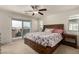 A main bedroom featuring a ceiling fan, sliding glass doors, a window, and carpet at 365 Andy Wheeler Dr, Henderson, NV 89011