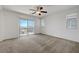 Bedroom with neutral carpet, ceiling fan, and sliding glass door to a balcony at 365 Andy Wheeler Dr, Henderson, NV 89011