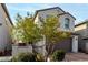 Two-story home with a paved driveway, desert landscaping, and a brown two-car garage at 365 Andy Wheeler Dr, Henderson, NV 89011