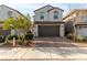 Two-story home with a two-car garage and a brick paved driveway and sidewalk at 365 Andy Wheeler Dr, Henderson, NV 89011