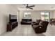 A cozy living room with tile floors, recessed lighting, a ceiling fan, a television, and a brown reclining sofa at 365 Andy Wheeler Dr, Henderson, NV 89011