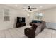 A bright living room featuring tile floors, recessed lighting, a ceiling fan, a television, and a brown reclining sofa at 365 Andy Wheeler Dr, Henderson, NV 89011