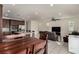 An open concept living room with a kitchen, dining area and a brown reclining sofa and a television at 365 Andy Wheeler Dr, Henderson, NV 89011