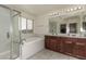 En-suite bathroom features dual sinks, a separate shower, and a luxurious soaking tub at 365 Andy Wheeler Dr, Henderson, NV 89011