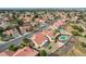 Expansive aerial view showcasing a neighborhood with red-tiled roofs, mature trees, and a home with a refreshing pool and yard at 412 Lost Trail Dr, Henderson, NV 89014
