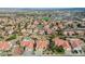 An aerial view showcasing a neighborhood featuring lush landscaping, swimming pools, and vibrant red-tiled roofs in a suburban setting at 412 Lost Trail Dr, Henderson, NV 89014