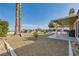 Large backyard area with gravel, a covered patio, a small grassy area, and desert landscaping providing a serene outdoor setting at 412 Lost Trail Dr, Henderson, NV 89014